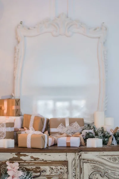 Kerstboom op houten ladekast commode bureau in wit interieur, versierd met kunstbloemen, bloemenslingers en speelgoed — Stockfoto