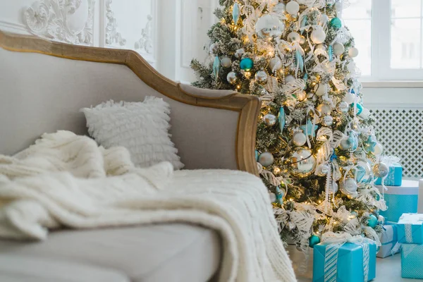 Новорічна або різдвяна прикраса у концепції інтер'єру вітальні та святкового домашнього декору. Спокійне зображення ковдри на вінтажному дивані з деревом, прогулянками, подарунками. Вибірковий фокус — стокове фото