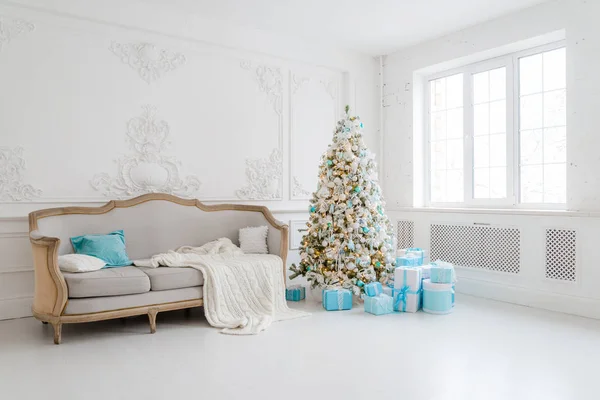 Elegante interior de Navidad con un elegante sofá. Hogar confortable. Regalos debajo del árbol en la sala de estar —  Fotos de Stock