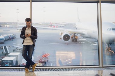 Genç iş adamı havaalanında smartphone kullanarak .