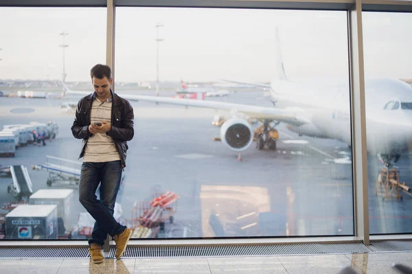 Young business man in airport using smartphone .