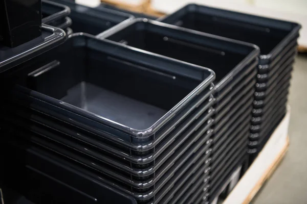 Schwarze Plastikbehälter stapeln sich in einem Geschäft — Stockfoto