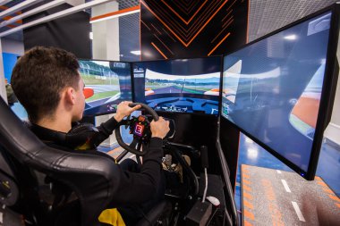 Moskova, Rusya - 27 Ekim 2018. Genç adam yarış simülatörü büyük ekranlı bir bilgisayar üzerinde çalış