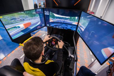 Moskova, Rusya - 27 Ekim 2018. Genç adam yarış simülatörü büyük ekranlı bir bilgisayar üzerinde çalış