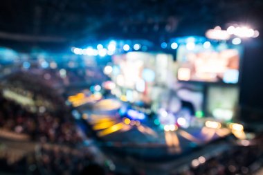 Blurred background of esports event at big arena with a lot of lights and screens. clipart