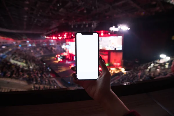 Крупним планом жінка тримає смартфон з порожнім мобільним телефоном з розмитим концертом. Копіювати простір . — стокове фото