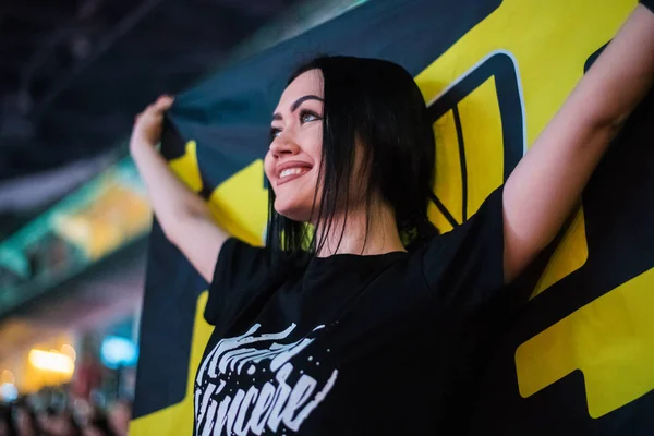 MOSCOW, RÚSSIA - OUTUBRO 27 2018: EPICENTER Counter Strike: Global Offensive esports event. Fã de menina feliz em um tribuno na arena com a bandeira de Natus Vincere de equipe. torcendo por sua equipe favorita . — Fotografia de Stock