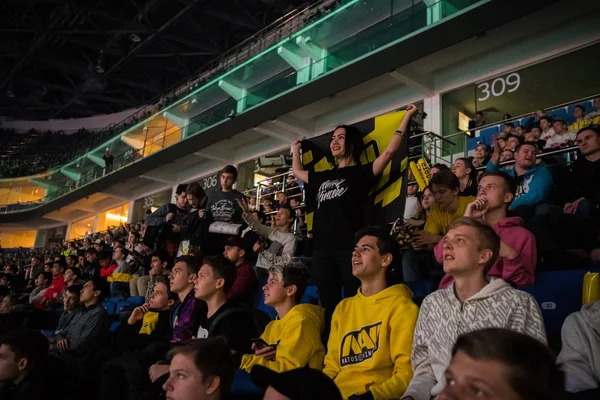 Μόσχα, Ρωσία - 2018 27 Οκτωβρίου: Επίκεντρο Counter Strike: παγκόσμια επιθετικά esports εκδήλωση. Ευτυχισμένος κορίτσι ανεμιστήρα σε μια tribune στο arena με ομάδα γραμμές Natus Vincere σημαία. Επευφημίες για την αγαπημένη της ομάδα. — Φωτογραφία Αρχείου