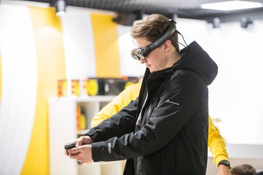 Moskova, Rusya - 27 Ekim 2018. Sanal gerçeklik kulaklık kullanarak ve teknoloji fuarında özel joystick ile çizim genç adam. Artırılmış gerçeklik ve eğlence kavramı