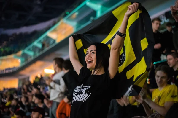 MOSCOW, RUSSIA - OCTOBER 27 2018: EPICENTER Counter Strike: Global Offensive esports event. Happy girl fan on a tribune at arena with team Natus Vincere flag. Cheering for her favorite team. — Stock Photo, Image