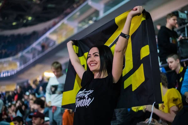 Μόσχα, Ρωσία - 2018 27 Οκτωβρίου: Επίκεντρο Counter Strike: παγκόσμια επιθετικά esports εκδήλωση. Ευτυχισμένος κορίτσι ανεμιστήρα σε μια tribune στο arena με ομάδα γραμμές Natus Vincere σημαία. Επευφημίες για την αγαπημένη της ομάδα. — Φωτογραφία Αρχείου