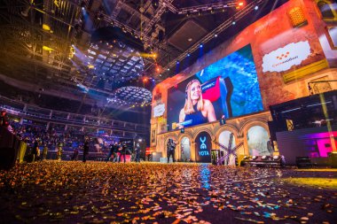 MOSCOW, RUSSIA - OCTOBER 27 2018: EPICENTER Counter Strike: Global Offensive esports event. Tournament is finished. Beautiful girl commentator on a big screen. Floor covered with a sparkles confetti clipart