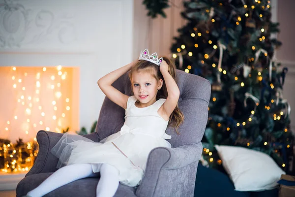 Mooi klein meisje zit in de fauteuil. Magie en feestelijke sfeer. — Stockfoto