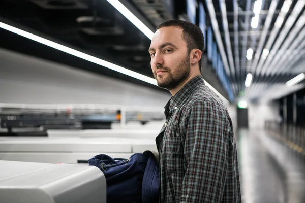 Jonge passagier met een paspoort en rugzak tijdens de registratie in de luchthaven voor de vlucht — Stockfoto