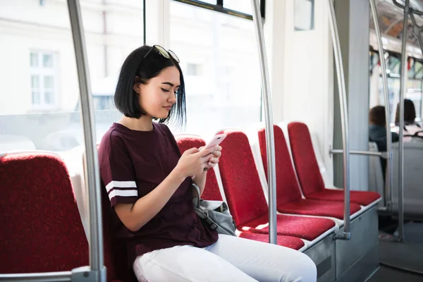 Νεαρή γυναίκα όμορφη περιήγηση και πληκτρολόγηση μηνυμάτων σε ένα δημόσιο λεωφορείο. — Φωτογραφία Αρχείου