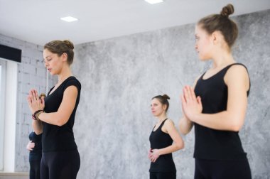 Fitness, meditasyon ve sağlıklı yaşam tarzı konsepti - Stüdyoda yoga yapan bir grup insan