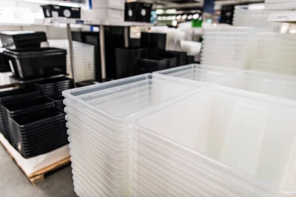 Transparente und schwarze Kunststoffbehälter stapeln sich in einem Geschäft — Stockfoto