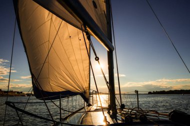Gün batımında ise açık deniz veya nehir seyir yelken yelkenli güverte. Rüzgarlı bir gün sonuna kadar tam yelken ile yat. Yelken tema - arka plan. Yatçılık arka plan tasarım.