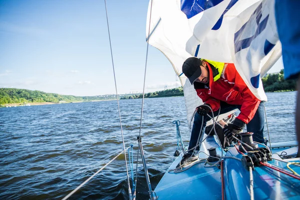 Yacht tengerész húz a kötelet. Vitorlás dolgozó férfi. — Stock Fotó