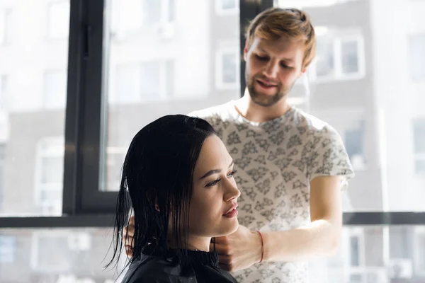 Smiling woman getting haircut by handsome hairdresser — Stock Photo, Image