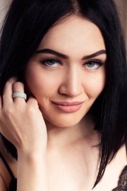 Güzel bir kadın yüzü portre yakın çekim, mükemmel cilt, saç ve dudakları ile bej mat ruj makyaj. Muhteşem halka jewerly parmağına.