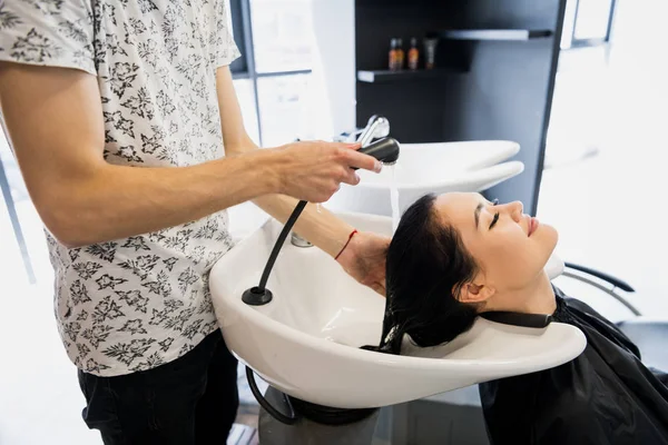 Salone da parrucchiere. La donna si siede durante lavaggio di capelli a salone . — Foto Stock