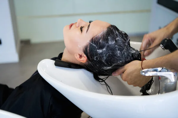 Парикмахерская. Женщина сидит во время мытья волос в салоне . — стоковое фото