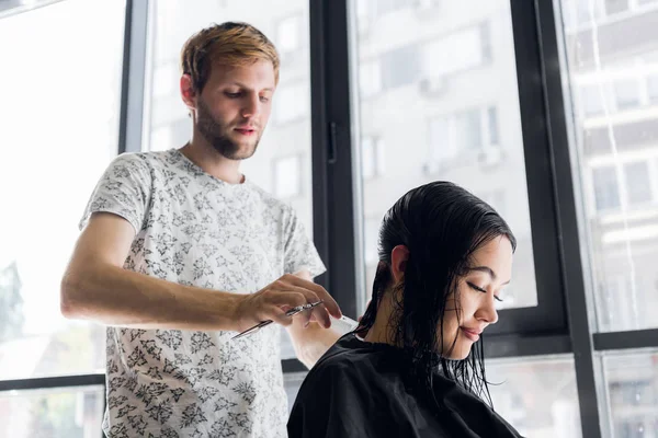 Kapper snijden klanten haren in salon met schaar close-up. Met behulp van een kam — Stockfoto