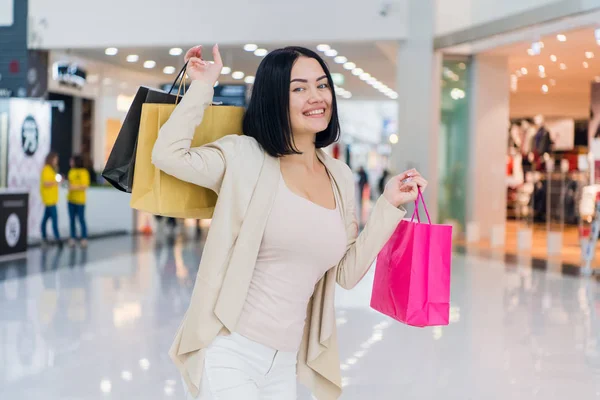 Porträtt av vacker ung kvinna med shoppingkassar går ut på en shoppingrunda. — Stockfoto