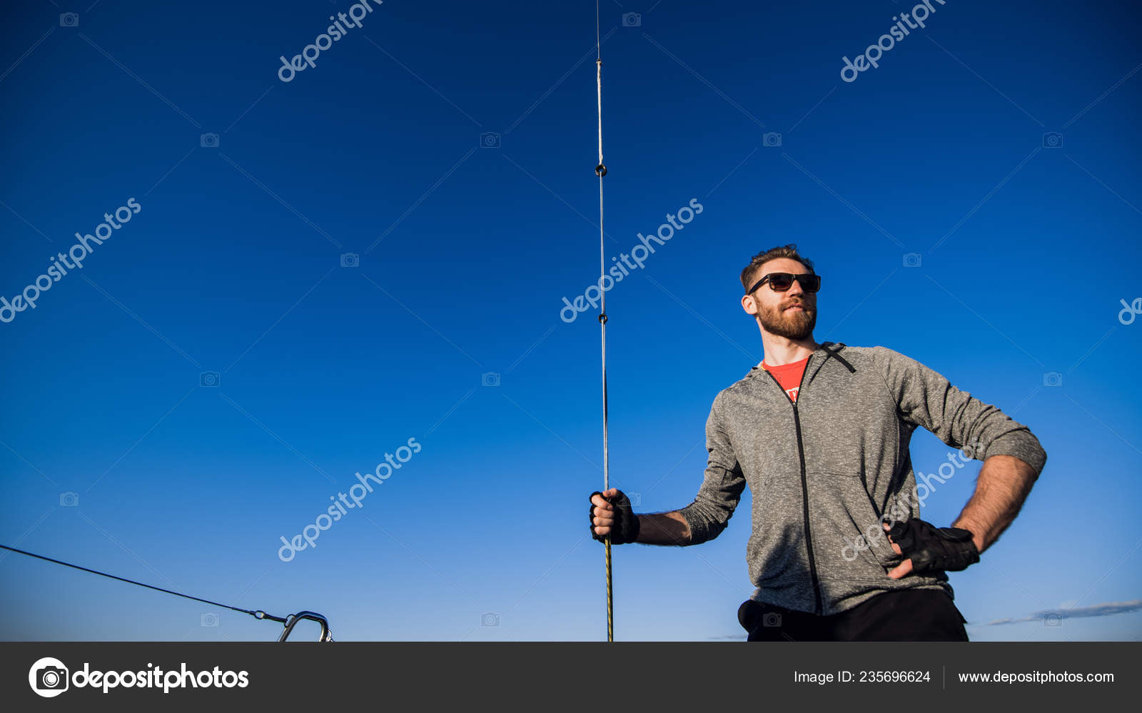 Low Angle Shot Of A Young Man Sailor Wearing Sunglasses And Gloves