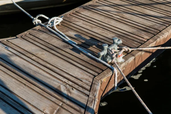 Dubbla förtöjning pollare kors på en bakgrund av havet i yachts piren. — Stockfoto