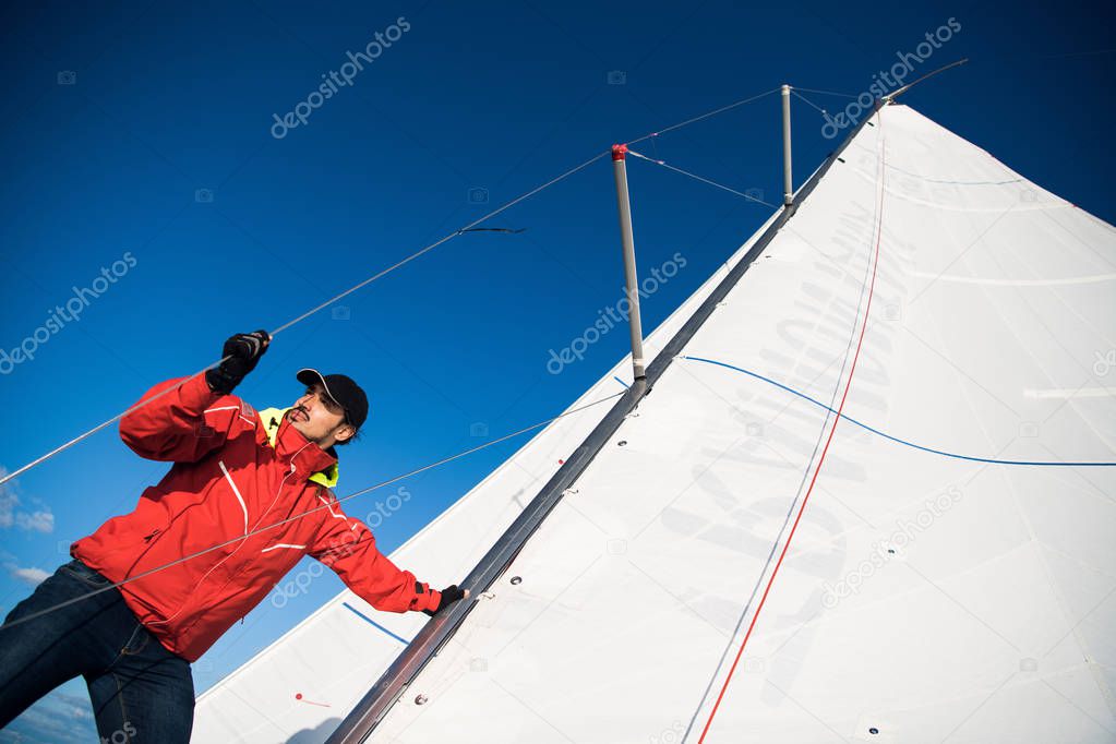 Young man working on sailing ship, active lifestyle, summer sport concept