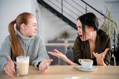 İki kadın cafede tartışıyor. Bağırarak ve el hareketi
