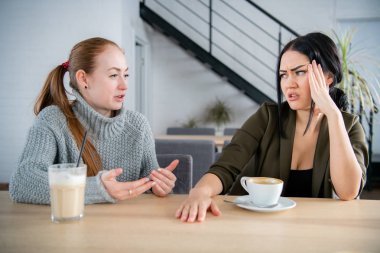 İki genç kadın cafede savunuyorlar. Duygusal konuşma