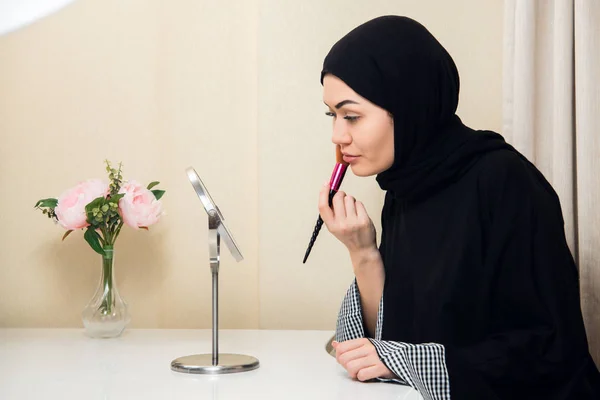 Arabiska kvinna tillämpa makeup på hennes ansikte, klädd i traditionell arabisk klädsel — Stockfoto