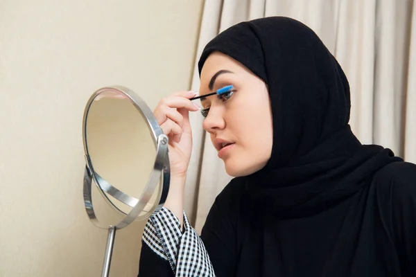 Hermosa mujer musulmana aplicando rímel. Mujer árabe joven usando cepillo de pestañas — Foto de Stock