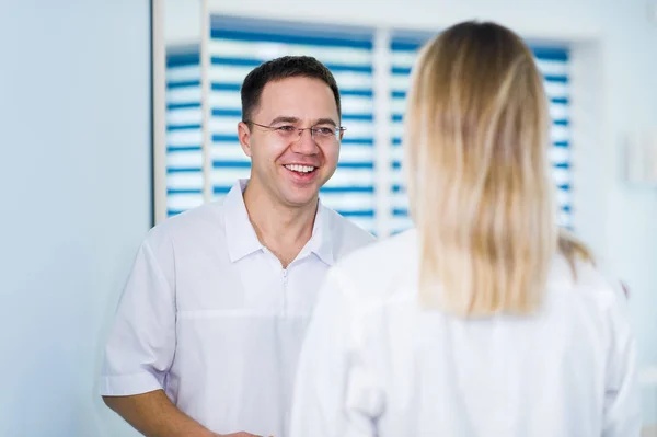 Médico hablando y riendo con su asistente de enfermería — Foto de Stock