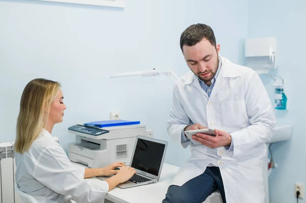 Equipo médico con tableta PC de pie y hablando en el hospital — Foto de Stock