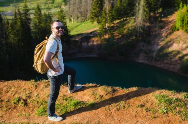 Doğada yürüyüş sırt çantası ile adam portre hiking. Beyaz adam yaz gezisi sırasında mutlu orman arka planda ile gülümseyen