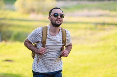 Doğada yürüyüş sırt çantası ile adam portre hiking. Beyaz adam yaz gezisi sırasında mutlu orman arka planda ile gülümseyen