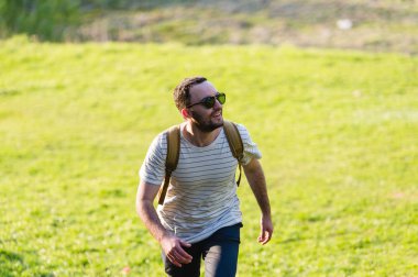 Doğada yürüyüş sırt çantası ile adam portre hiking. Beyaz adam yaz gezisi sırasında mutlu orman arka planda ile gülümseyen