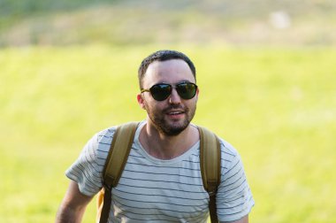 Doğada yürüyüş sırt çantası ile adam portre hiking. Beyaz adam yaz gezisi sırasında mutlu orman arka planda ile gülümseyen