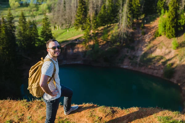 Yürüyüş yapan, gülümseyen mutlu bir portre. Ormanda yürüyen erkek yürüyüşçü