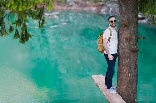 녹색 자연과 푸른 호수는 나무 근처에 서에 잘생긴 남자. 모험, 여행, 관광 및 레저 개념-어린 소년 숲에서 휴식. — 스톡 사진
