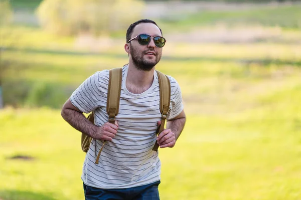 Wandelen man staand met rugzak, wandelen in de natuur. Kaukasische man die lacht tevreden bos in achtergrond tijdens zomer reis — Stockfoto