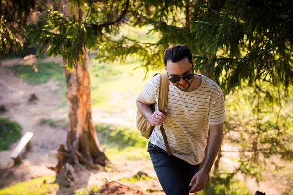 Hombre usando senderismo con mochila al aire libre en el bosque — Foto de Stock