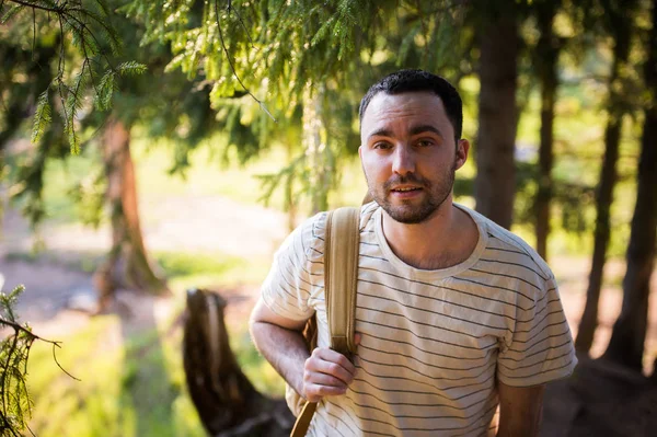 Молодий чоловік гуляє усміхненим щасливим портретом. Чоловік ходить пішки в лісі — стокове фото