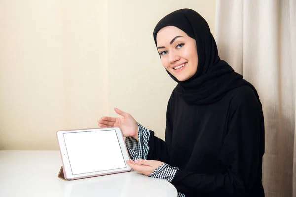 Mujer musulmana sosteniendo la tableta con pantalla en blanco en casa u oficina. Concepto de copyspace tecnológico — Foto de Stock