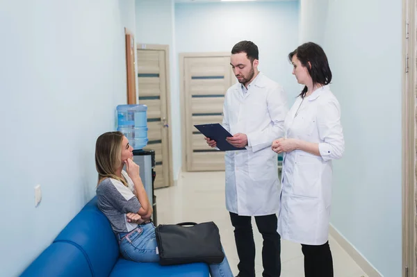 Un médico y una enfermera discuten el diagnóstico con el paciente o familiar en el piso del hospital — Foto de Stock