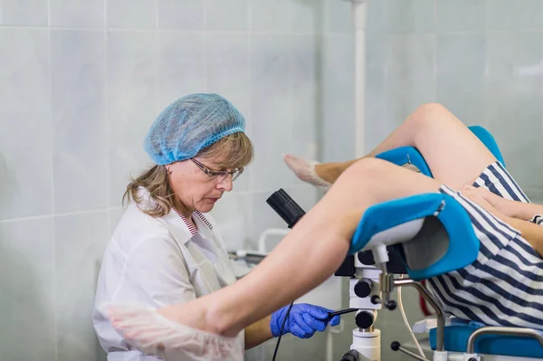Professional gynecologist examining her female patient on a gynecological chair. — Stock Image Professional gynecologist examining her female patient on a gynecological chair. Stock Photo